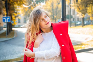 Güzel sonbahar parkında kırmızı ceket giyen tatlı genç kız, konsept sonbahar.