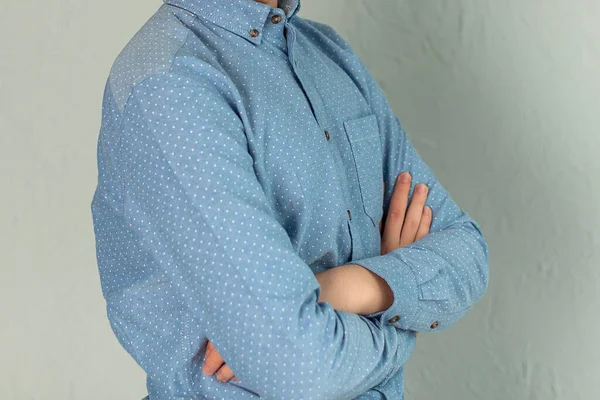 青いシャツを着た若い男が灰色の背景に立っている — ストック写真