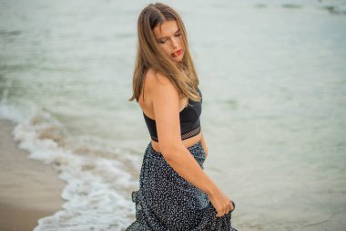 Kumsalda güzel bir genç kız ya da kadın. Temiz hava plajı manzarası. Doğal güzellik. Yaşam tarzı / gerçek insanlar / komik / dans.