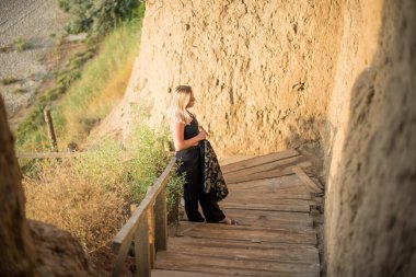 Moda kadını. Kumsalda güzel bir genç kız ya da kadın. Temiz hava plajı manzarası. Doğal güzellik. Yaşam tarzı, gerçek insanlar. Parlak makyaj, kırmızı dudaklar..