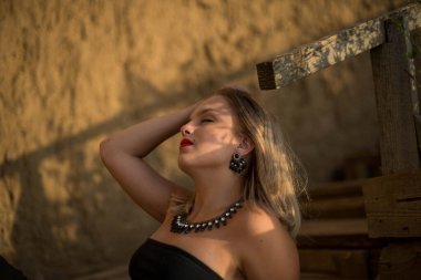 Moda kadını. Kumsalda güzel bir genç kız ya da kadın. Temiz hava plajı manzarası. Doğal güzellik. Yaşam tarzı, gerçek insanlar. Parlak makyaj, kırmızı dudaklar..