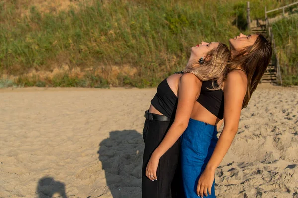 Happy young people running on beach and enjoying summer holiday. two young beautiful girls walking on beach