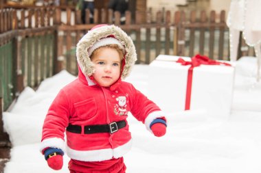 Kırmızı Noel Baba kostümlü küçük kız. Noel aile tatili konsepti. Mutlu Noeller ve mutlu tatiller. Kış yürüyüşü.