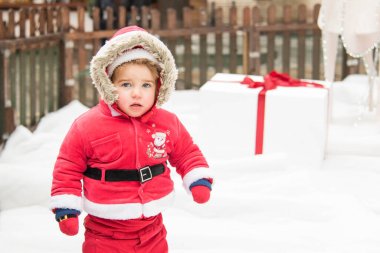 Kırmızı Noel Baba kostümlü küçük kız. Noel aile tatili konsepti. Mutlu Noeller ve mutlu tatiller. Kış yürüyüşü.