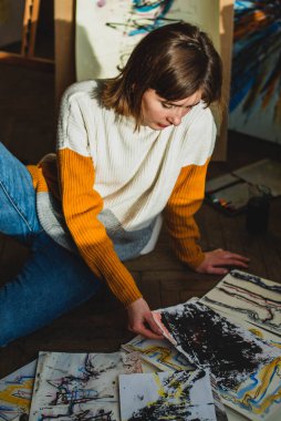 Güzel bir kadın resmi. Resim stüdyosundaki kız. Yetenekli Kadın Sanatçı Modern Soyut Yağlı Boyama, Geniş Vuruşlar Kullanarak Hareketlendirme Boya Fırçası üzerinde çalışıyor. Karanlık Yaratıcı Stüdyo