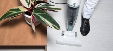 Elektrikli süpürgeli kadın bacakları. Yerler boşaltılıyor. Ev temizliği. Evde servis kavramı, daireler, otel.. 