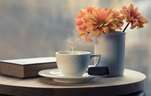 Witte Koffiebeker Met Rook Vaas Met Sinaasappelbloemen Bruin Boek Tafel — Stockfoto