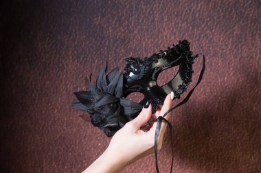 Karnaval maskeli kadın eli, karanlık arka plan, kopyalama alanı