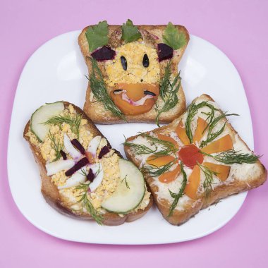 Yenilebilir inek boğalı sandviç ve pembe arka planda çiçek. Noel ve Yeni Yıl için gıda sanatı fikri 2021. 