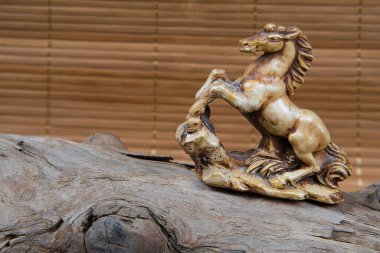 Japon netsuke figürünün ahşap ve bambu arka plandaki yakın çekimi. Heykel at maskotu