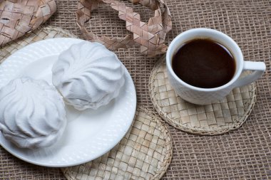 Ev yapımı marşmelov ve kahve fincanı. Doğal çuval bezi arka planında kremalı kurabiye.. 