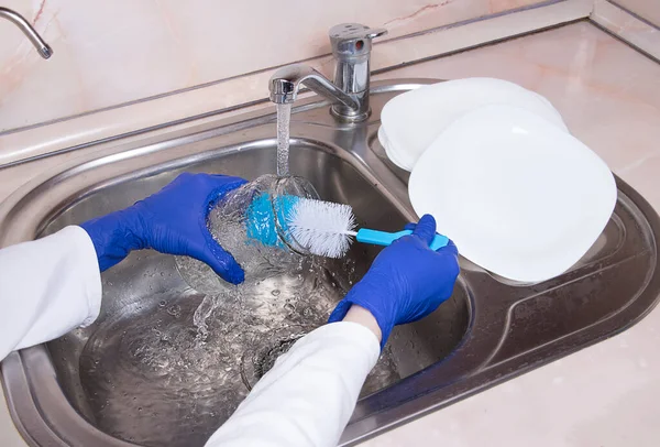 Mãos Femininas Com Luvas Azuis Lavando Frasco Vidro Torneira Cozinha — Fotografia de Stock