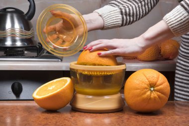 Portakal sıkacak kadın eli. Kadınların eline yakın çekim taze portakal suyu yapıyor. Portakal suyu sıkmak