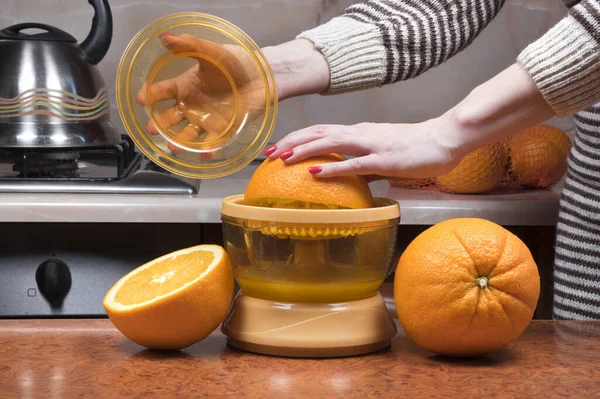 Portakal sıkacak kadın eli. Kadınların eline yakın çekim taze portakal suyu yapıyor. Portakal suyu sıkmak