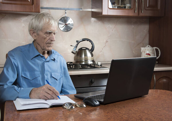 Senior man studying laptop.  Old man learning computer at kitchen. Online education and consulting