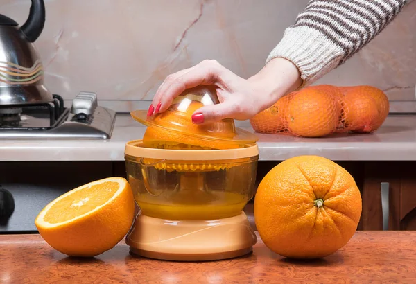 Kadınların eline yakın çekim taze portakal suyu yapıyor. Portakal suyu sıkan kadın eli. Portakal sıkma