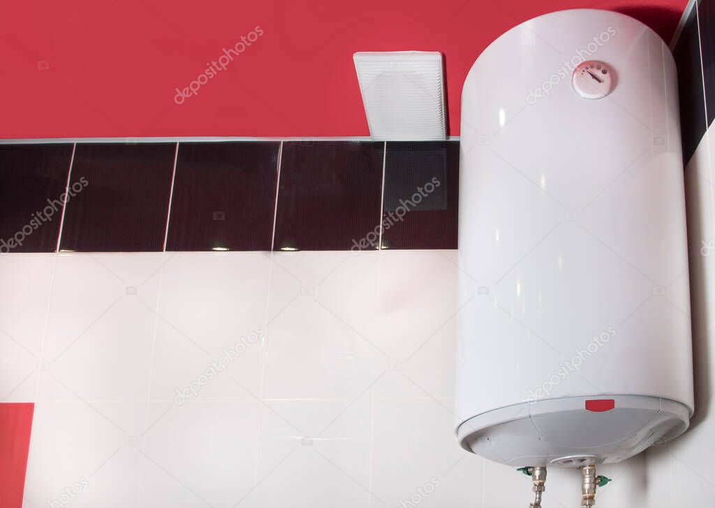 Tank electric water heater on white and red tiled wall. Copy space for text