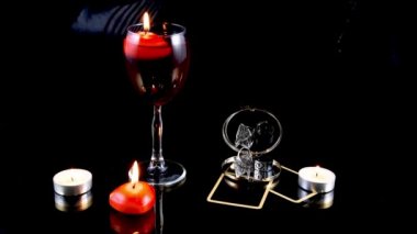 Tarot kartlarıyla sihirli seanslar, kırmızı mumlar, yüzükler, ayna ve siyah arka planda şarap kadehleri. Gizemli falcılık. Sihirli atmosfer.