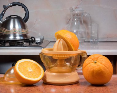 Elle meyve suyu çıkarıcı. Portakal sıkmak. Evdeki mutfak masasında portakallı elektrikli sıkma sıkacağı.. 