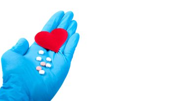 Eldivenli doktorun elinde kırmızı kalp sembolü ve beyaz arka planda izole edilmiş haplar var. Tedavi kalp hastalıkları.