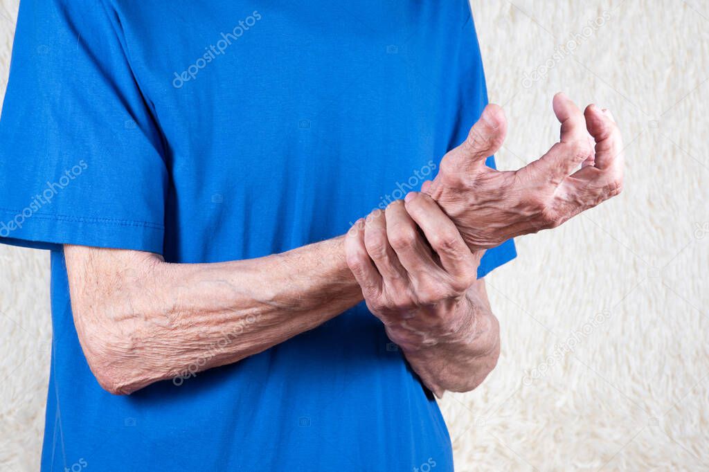 Male hand holding wrist. Eldery man suffering from pain in hand. Bone disease, arthritis or arthrosis.