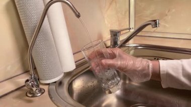 Su filtresinden filtrelenmiş suyu cama döküyorum. Lavabo ve musluğu kapatın. Mutfakta içilebilir su