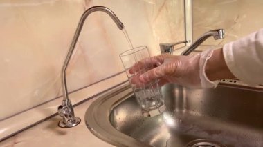 Su filtresinden filtrelenmiş suyu cama döküyorum. Lavabo ve musluğu kapatın. Mutfakta içilebilir su