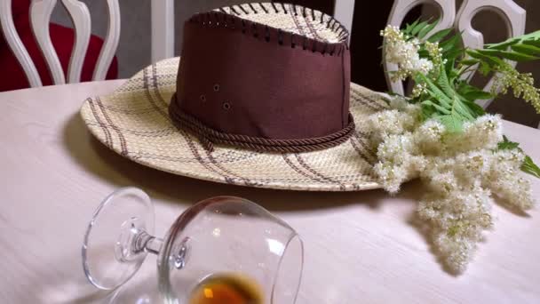Cappello Cowboy Bicchiere Vino Con Whisky Sul Tavolo Bianco Camera — Video Stock