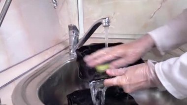4k Timelapse. Kadınlar mutfak lavabosunda siyah tabakları çabucak yıkarlar. Musluğu kapatın ve kadın eli eldivenli olsun.. 