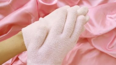 Pembe arka planda 4k spa jeli nemlendirici eldivenler. Cilt bakımı ve güzellik rutini kavramı.