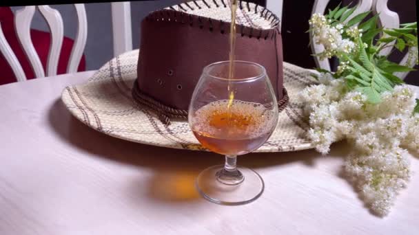 Cappello Cowboy Bicchiere Vino Con Whisky Sul Tavolo Bianco Camera — Video Stock