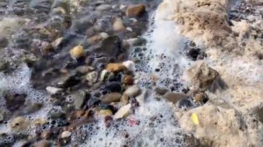 4k Su Kirliliği. Su yüzeyinde köpük ve taşlar. - Yakın çekim. Seçici odaklanma. Çevre koruma kavramı.
