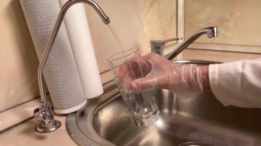 Su filtresinden filtrelenmiş suyu cama döküyorum. Lavabo ve musluğu kapatın. Mutfakta içilebilir su