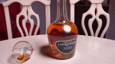 Masada bir şişe Courvoisier Vsop ve şarap kadehi. Fransız konyak perması, RUSSIA, 22 Haziran 2021.