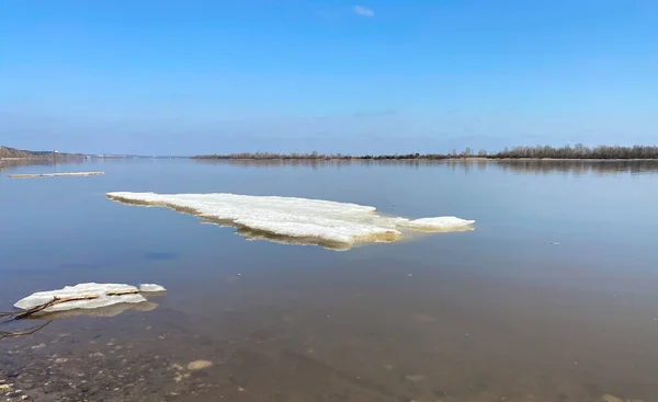 Spring thawed ice on lake. Background texture. Frozen ice and snow by river side.