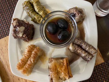 Kafede beyaz tabakta oryantal tatlılar. Orta Doğu tatlısı