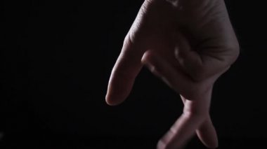 Siyah arka planda bir adam öfkeyle yumruğunu sıkıyor.