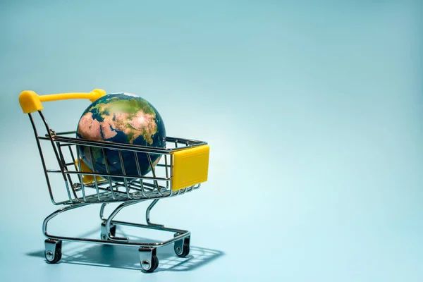 Планета Земля в тележке супермаркета, онлайн шоппинг. Концептуальное фото Дня Земли Стоковое Изображение