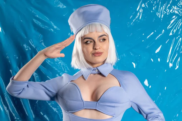 Mavi lateks arka planda mavi üniformalı hoş bir hostes.