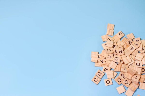 wooden alphabet a bunch letters on the surface of a blue background