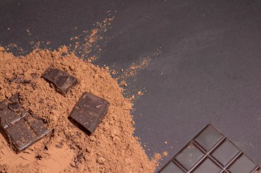 Çubuk, farklı süt ve koyu çikolata parçaları, gri arkaplan manzaralı rendelenmiş kakao. Yakın plan..