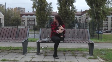 Depresyonda olan evsiz bir kız ya da şapkalı bir kadın sokağın ortasında tek başına oturuyor. Ümitsiz ve endişeli bir şekilde odaklanıyor.