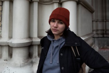 Çok genç, aç ve korkmuş evsiz genç kız soğuk kış gününde şehir sokaklarında tek başına dikiliyor. Gerçek insanlar seçici odaklanıyor.