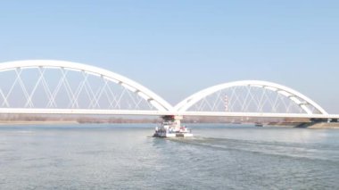 Mavna satıcı gemisi ve römorkör köprünün altından geçerek nehri daha hızlı geçiyor.