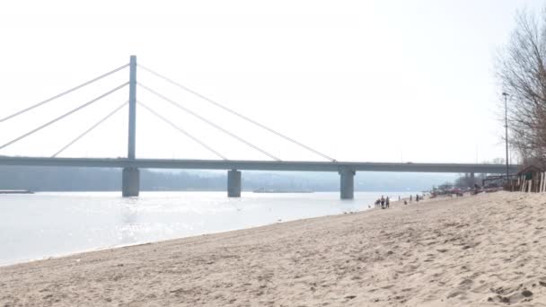 ドナウ川と空のビーチストランドの上の橋の建設11月悲しい セルビアの選択的フォーカス — ストック動画