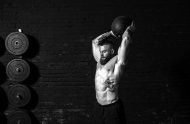 Genç, terli, güçlü, kaslı, kaslı, top fırlatan, spor salonunda antrenman yapan, gerçek insanlar gibi.