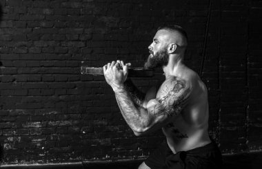 Genç, terli, güçlü, kaslı, iri kaslı, kuku kaldıran güçlü kaslı bir adam ya da spor salonunda ağır halter plakalı bir hıyar. Çapraz egzersiz yaparken gerçek insanlar egzersiz yapıyor.