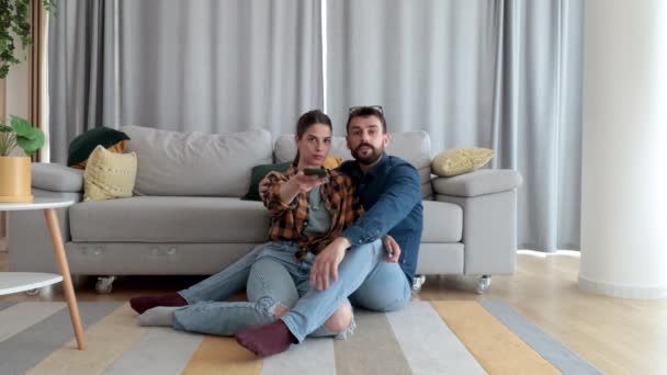 Feliz Pareja Joven Sentada Suelo Acogedora Casa Viendo Programas Cambio — Vídeo de stock