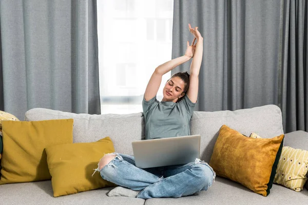 Genç, mutlu, serbest girişimci kadın evinde dizüstü bilgisayarla oturuyor ve gülümsüyor çünkü internetten bulduğu bir iş için çok önemli bir proje ödevini tamamladı. İş konsepti.