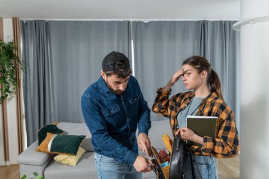 Genç çift tartışıyor çünkü kadın cüzdanından evini ya da arabasının anahtarlarını kaybetmiş ve bir erkek eli onları deli bir yüz ifadesiyle çantasında bulmaya çalışıyor.
